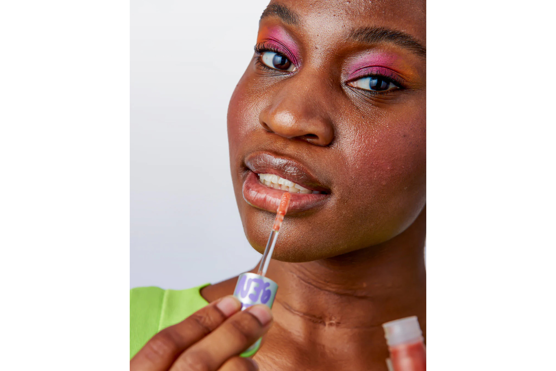 Woman wearing makeup applying Glow Hub lip gloss