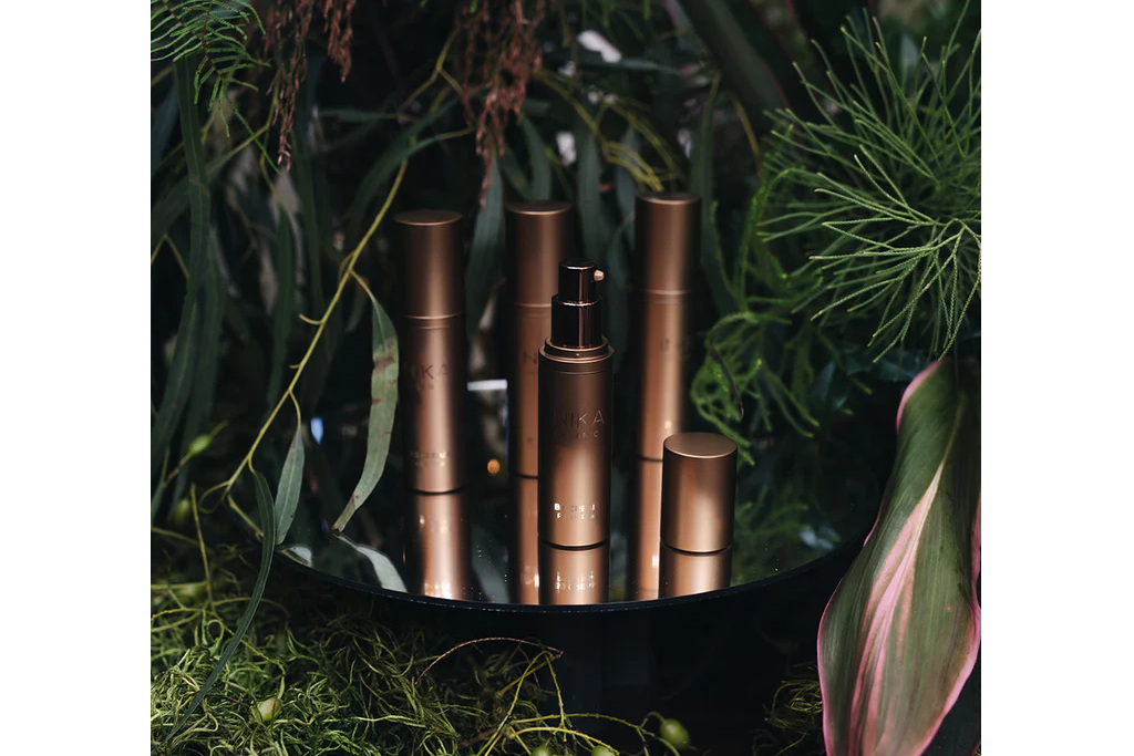 Bronze bottles on table surrounded by foliage