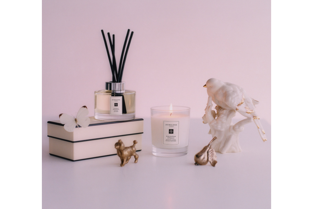 Jo Malone products scattered across warmly lit white space