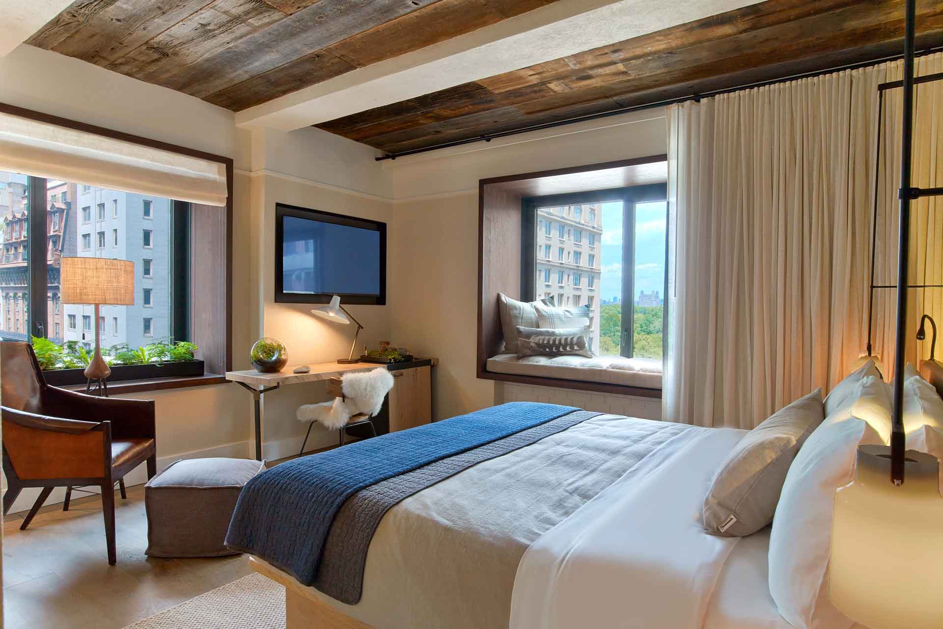 Hotel room with blue accents and a view of Central Park