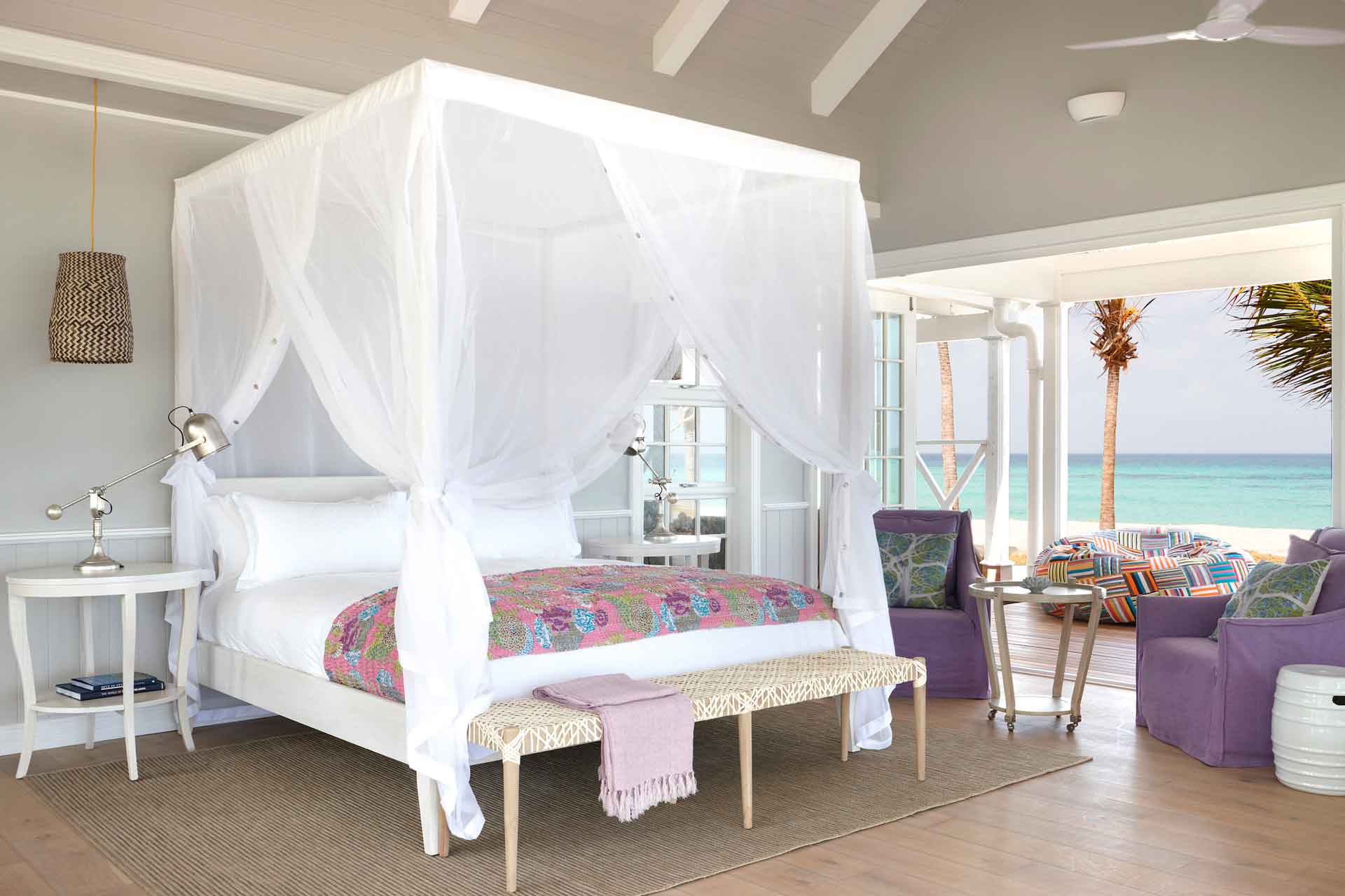 Hotel room with beach view and double bed with white canopy