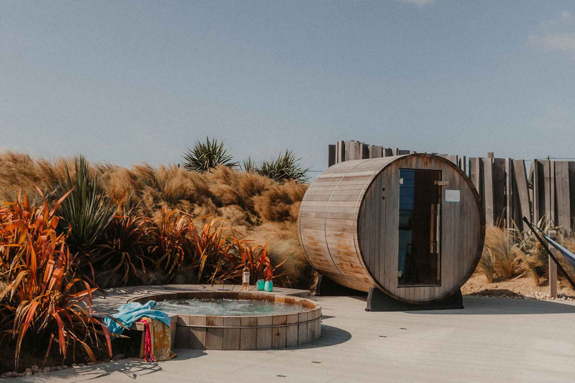 A sauna on the beach beside a hottub