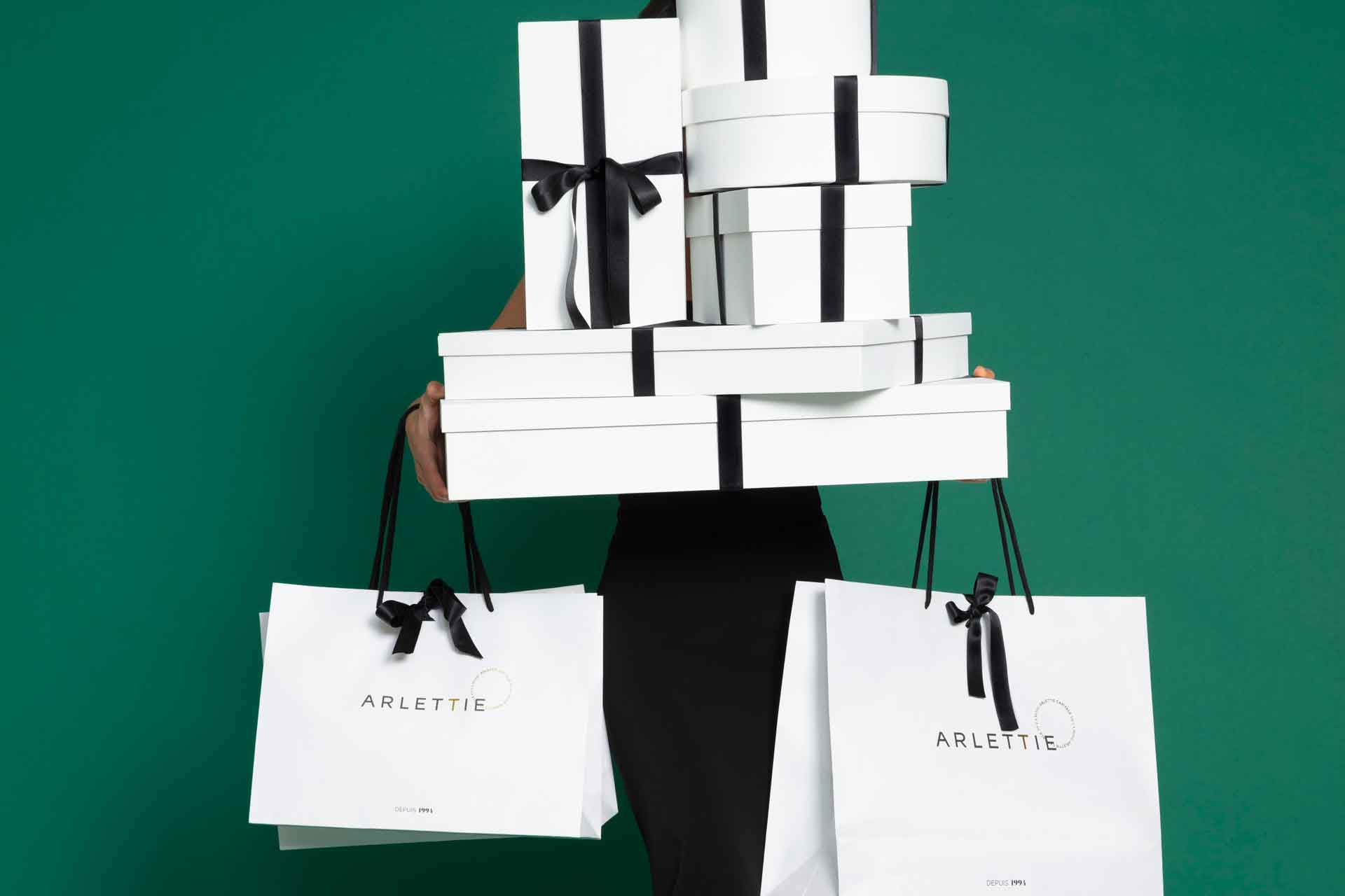 Stacks of shopping bags obscuring model's face