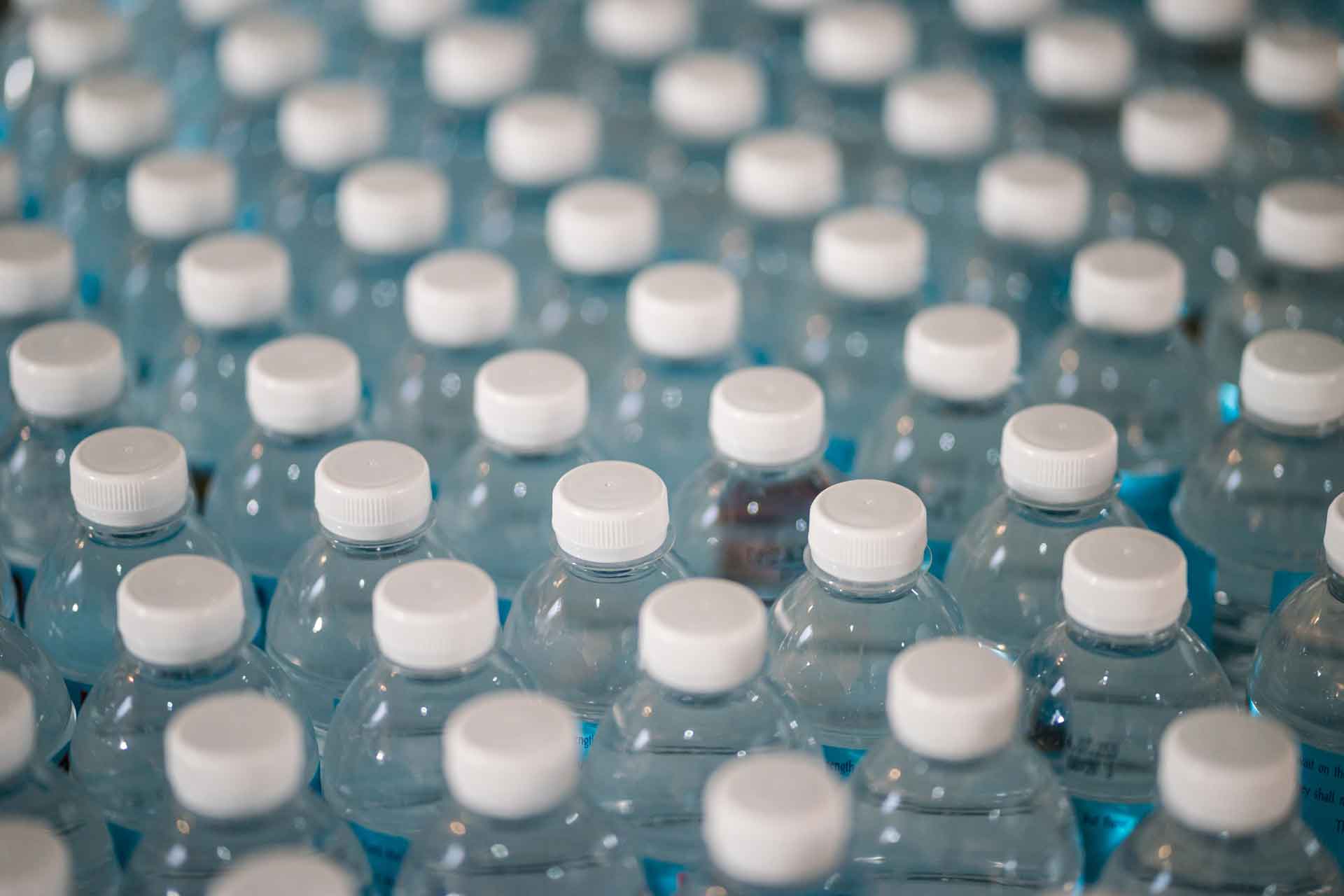 Rows of plastic water bottles with white plastic caps