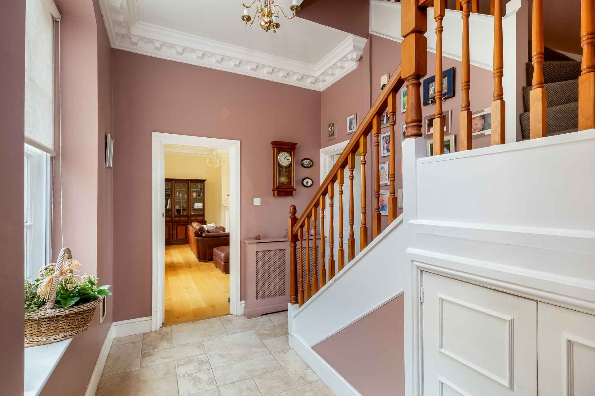 Hallway with dusty pink walls and white cornicing