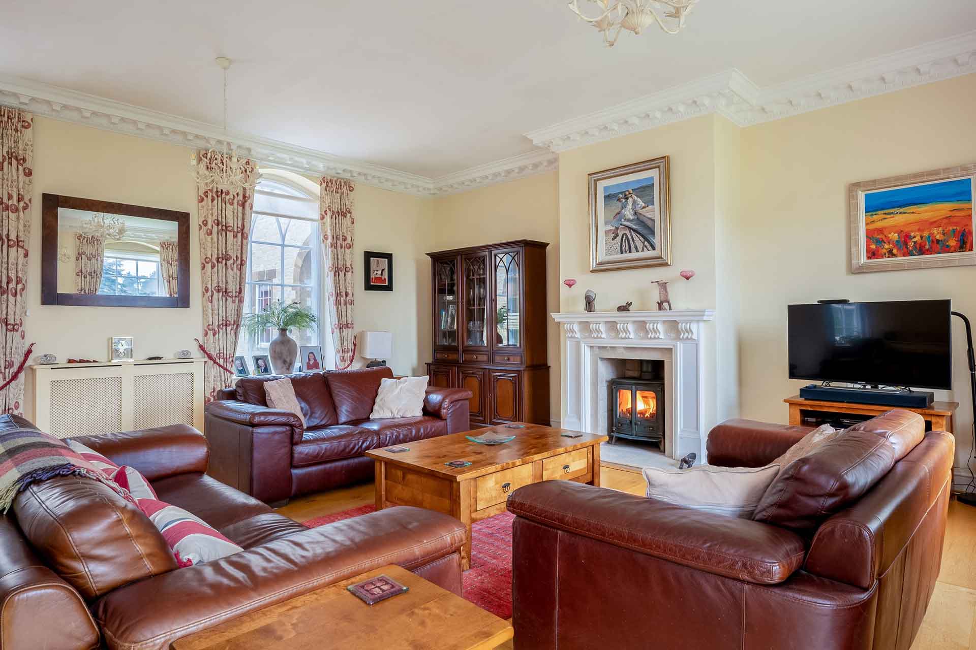 Living room with cream walls and brown leather sofas.