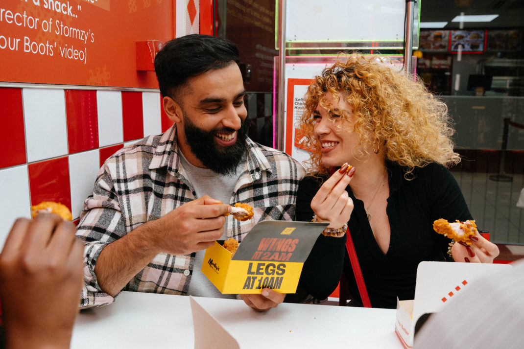 Woman and man eating chicken in Morley's