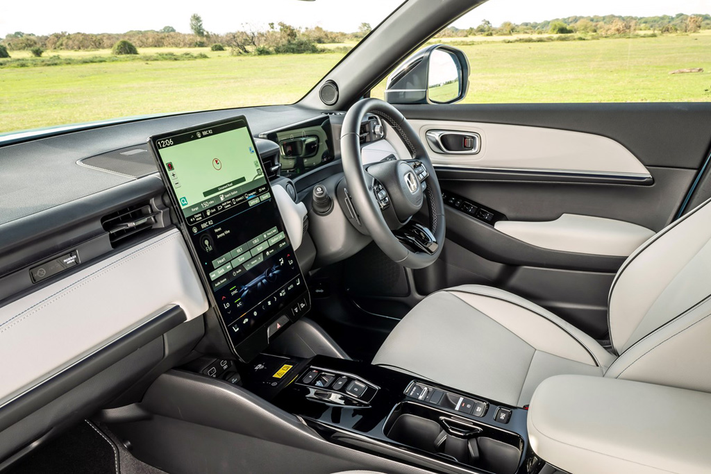 The interior of the Honda e:Ny1 with the infotainment system and steering wheel