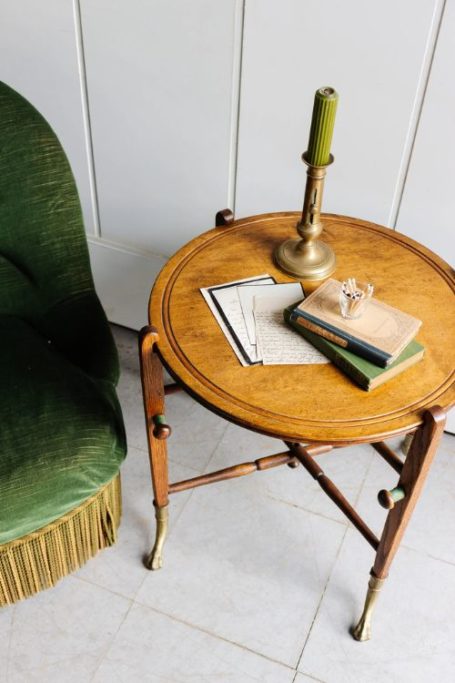 Wooden side table with green armchair