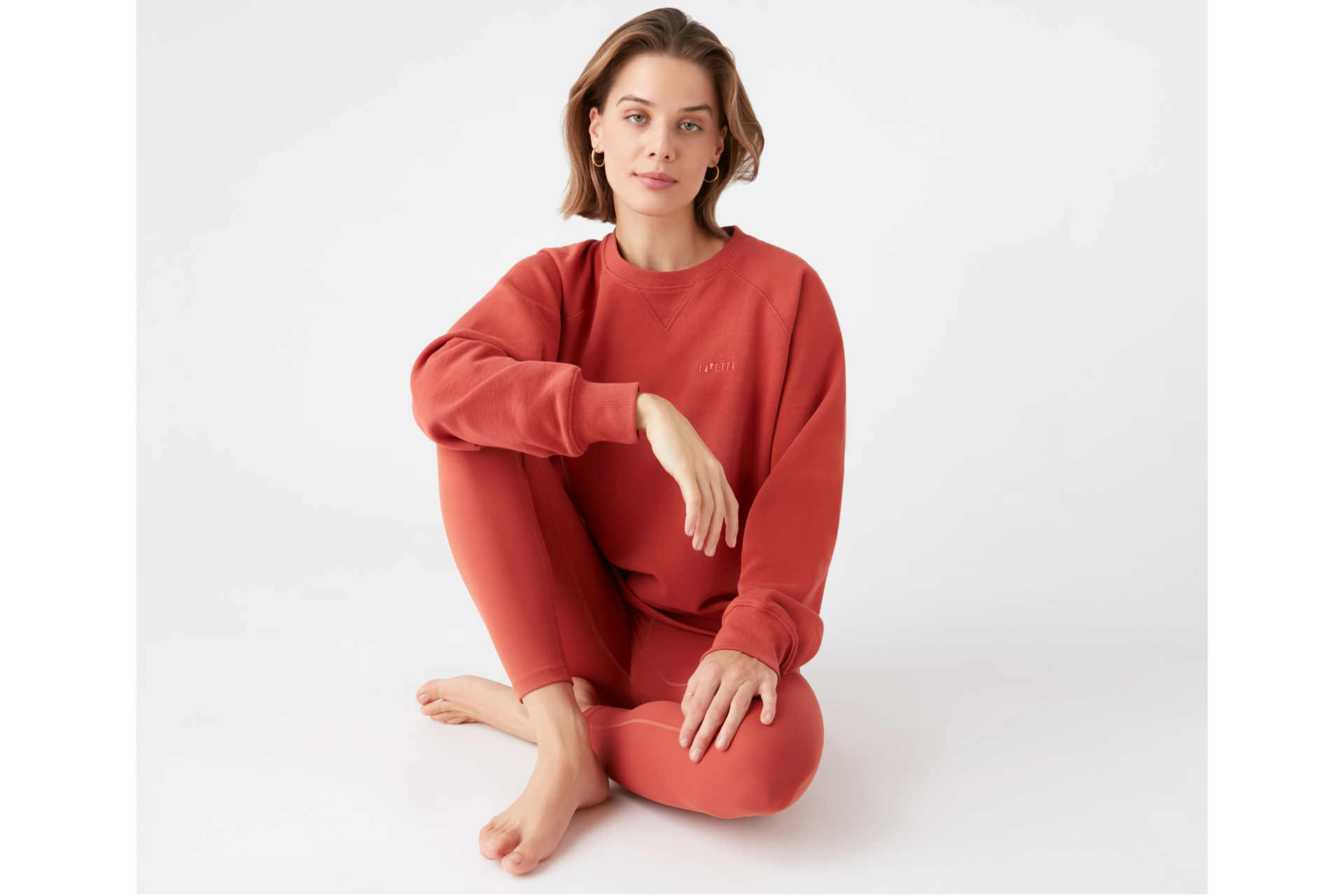 A model in orange LAVETTA activewear