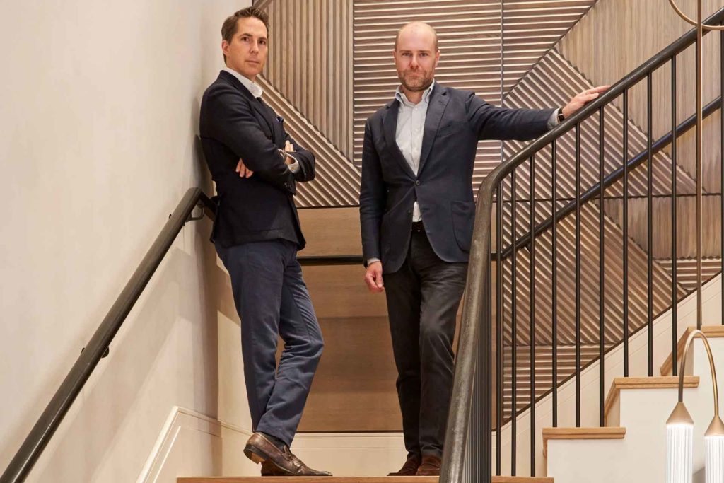 Alex Michelin and Matthew Robertson portrait, on a staircase of their contemporary London office building.