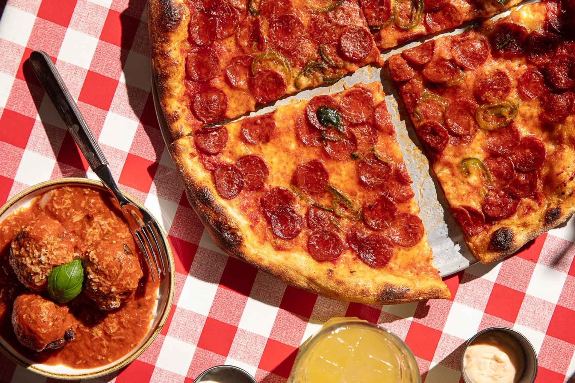 Aerial view of pepperoni pizza on gingham tablecloth