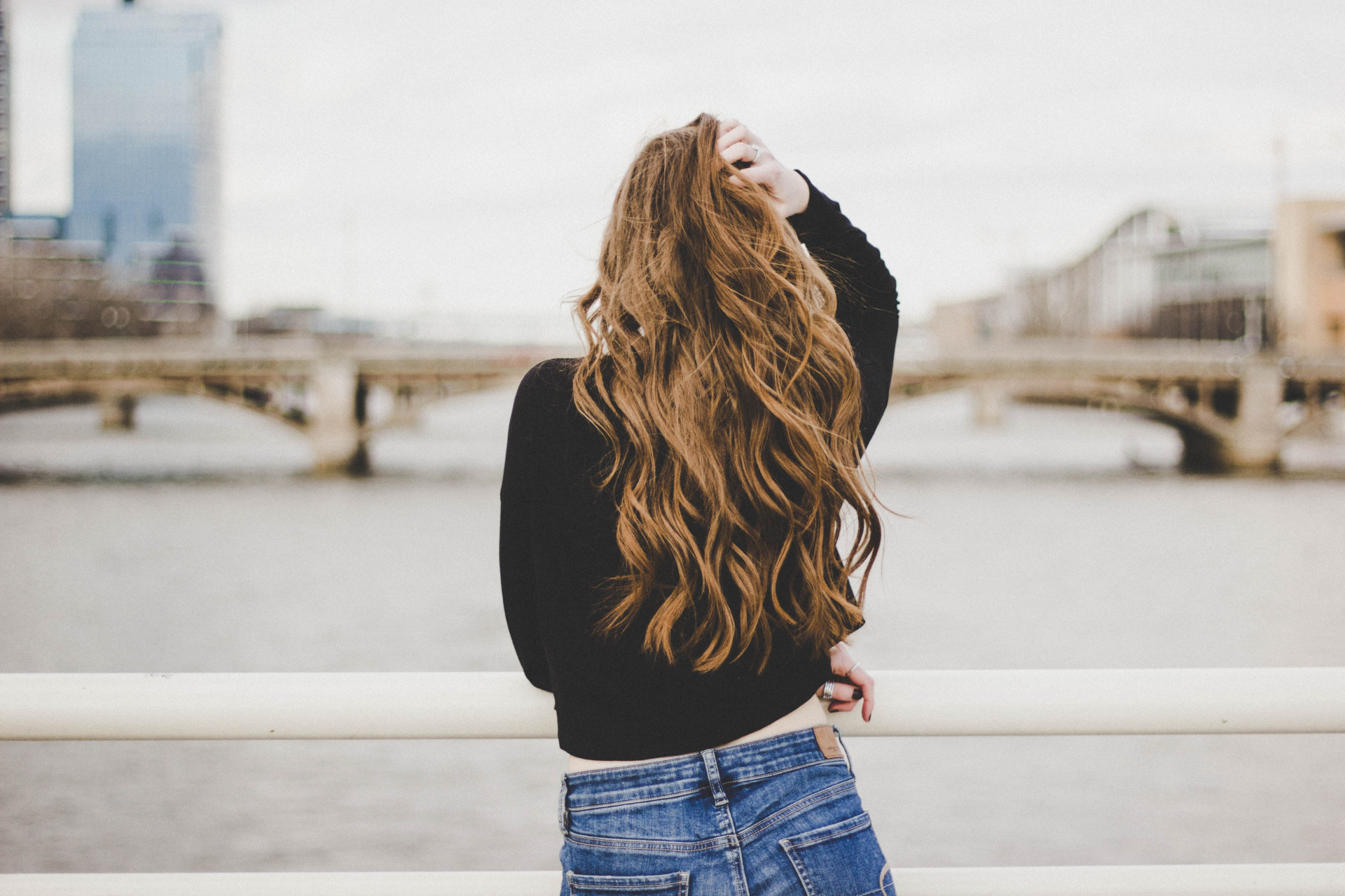 Woman looking out from bridge with butterfly haircut