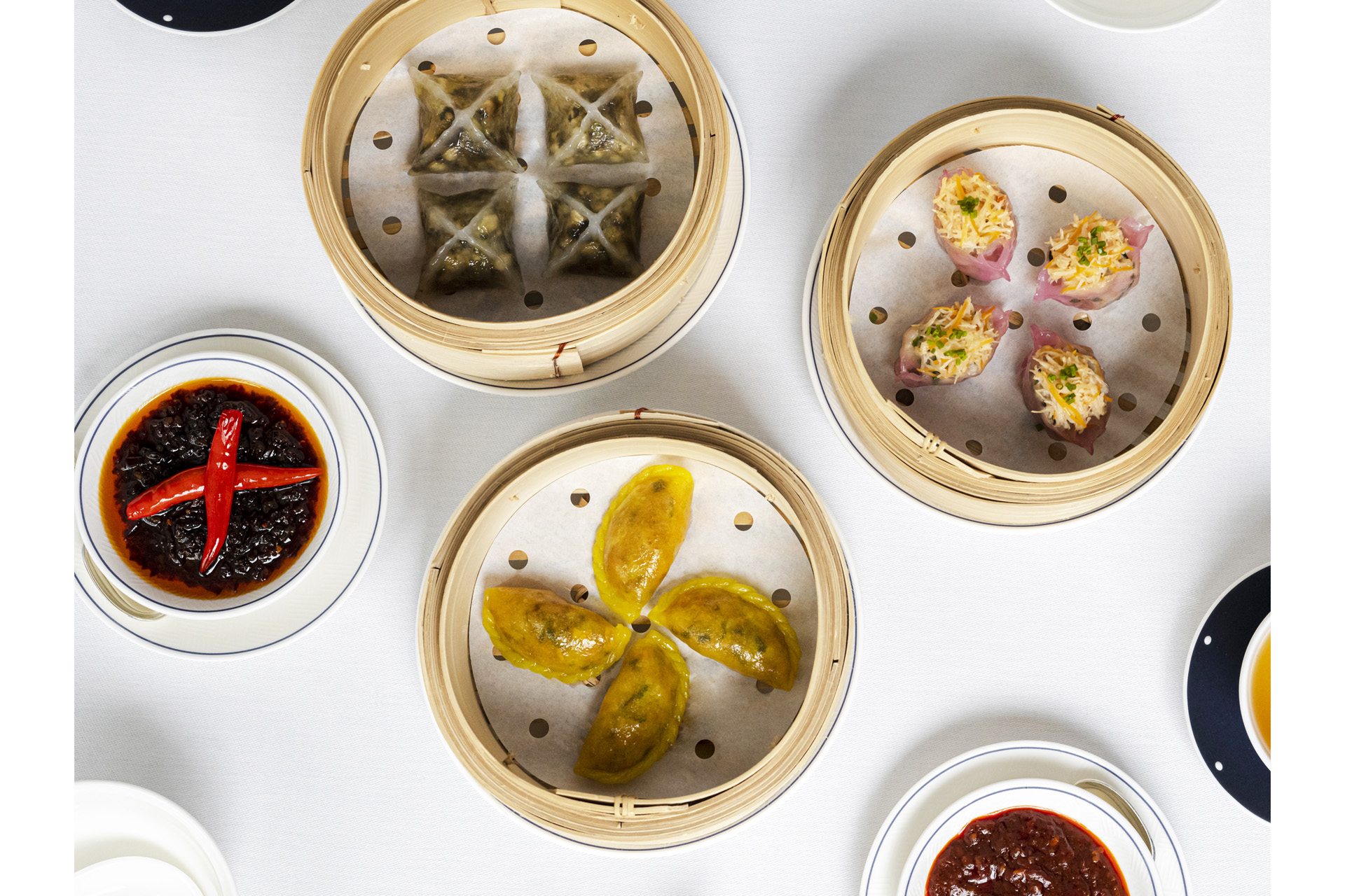Plates of dim sum on a white table