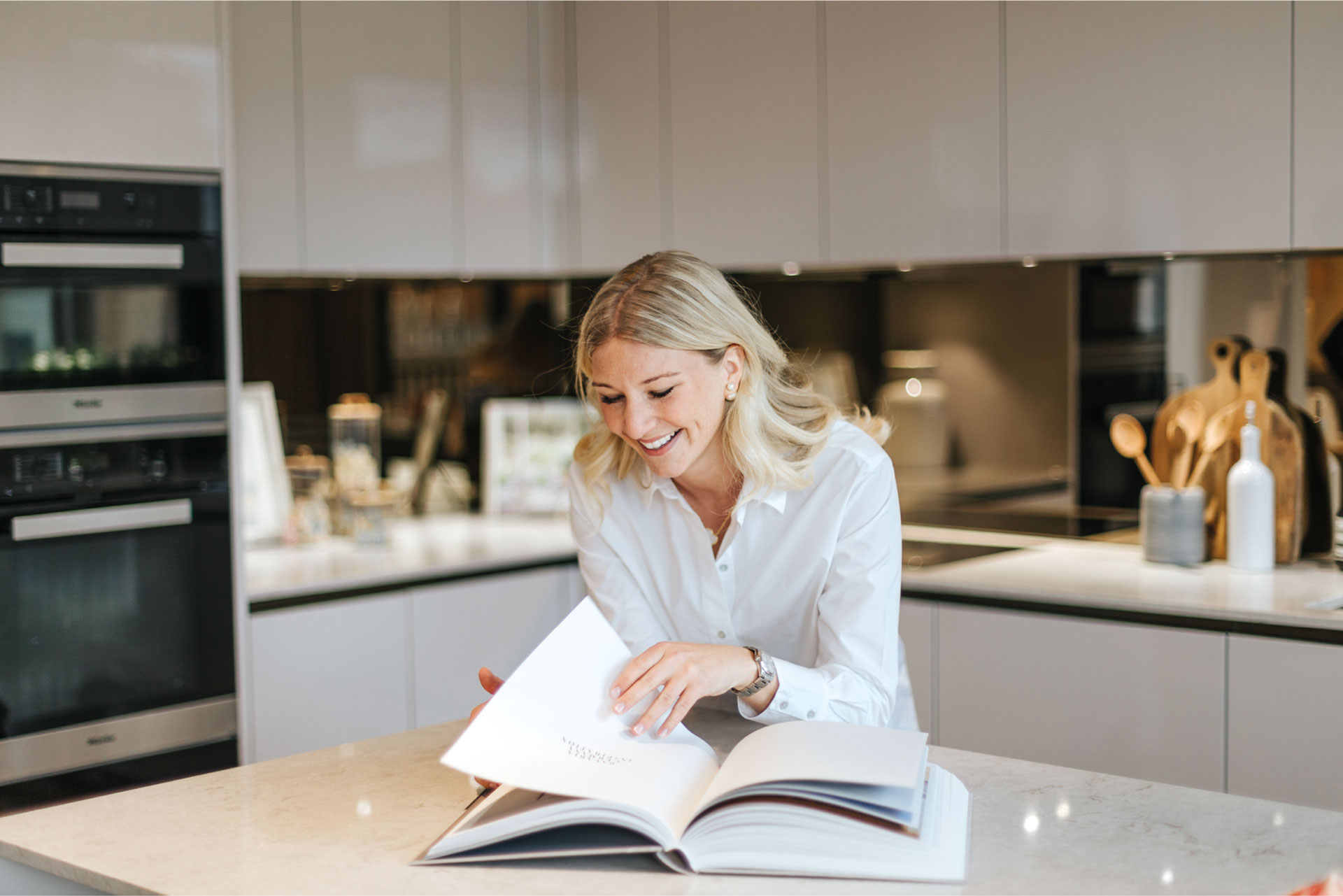 Charlotte Elizabeth Interiors blonde woman reading book in kitchen