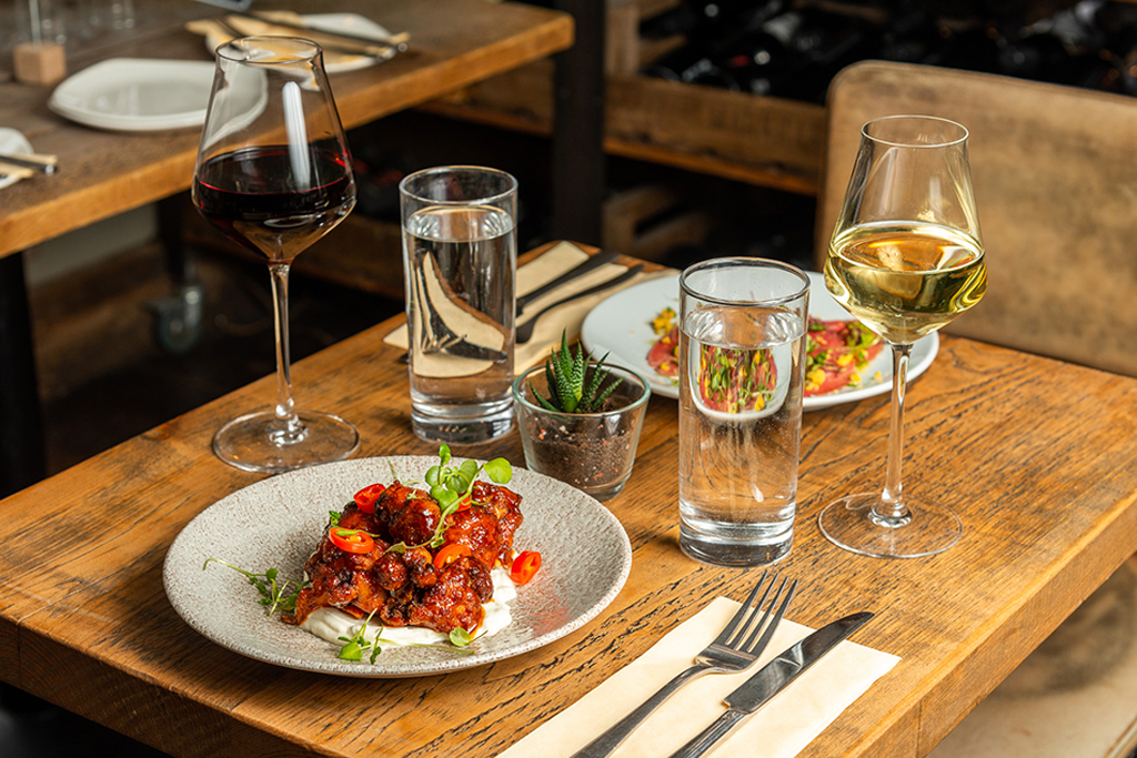 A table with two dishes and glasses of wine