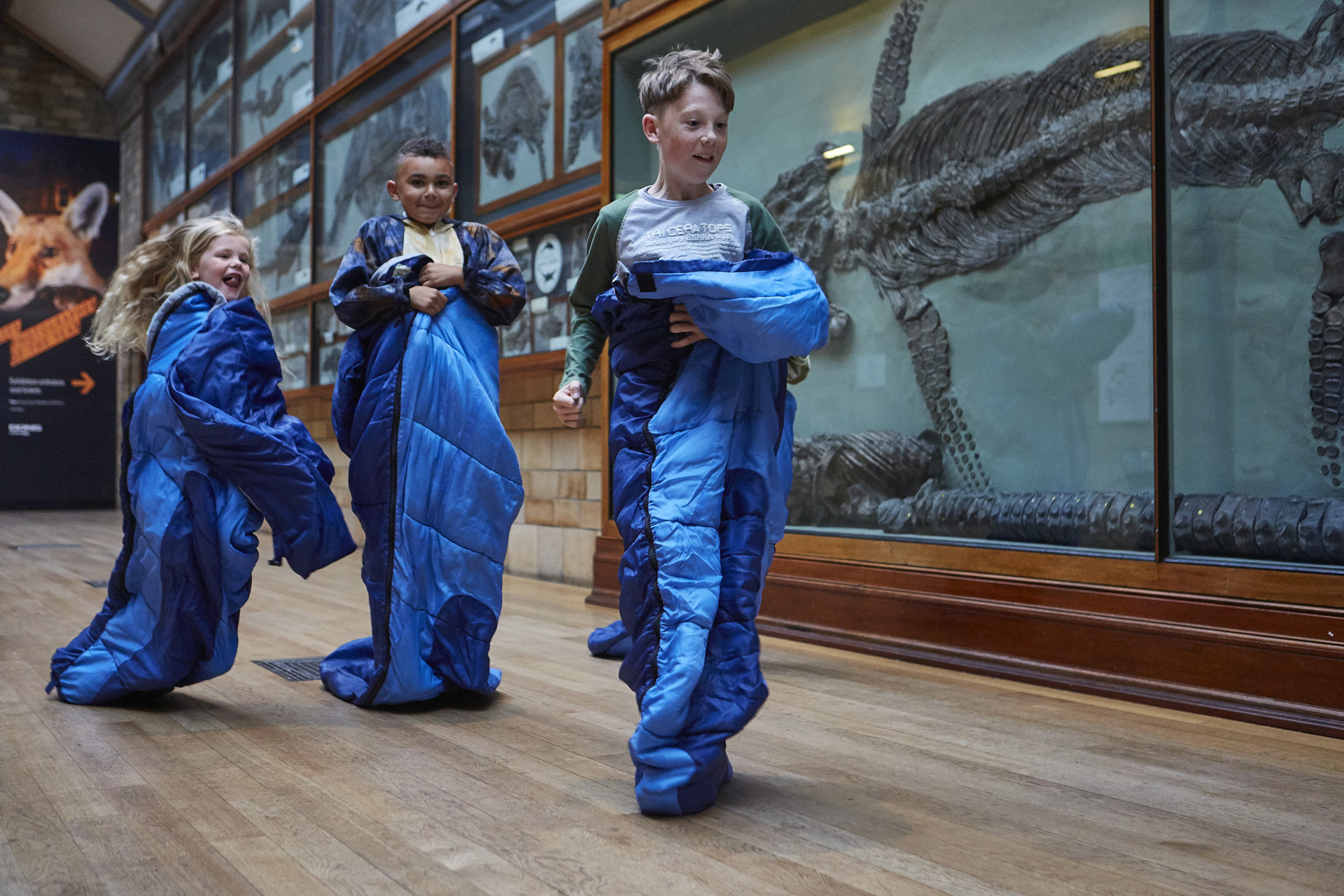 Kids in sleeping bags walking through the museum