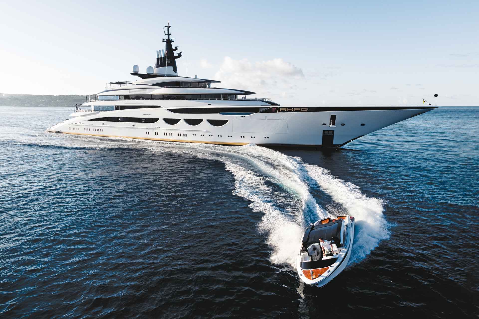 Yacht with smaller boat sailing in front