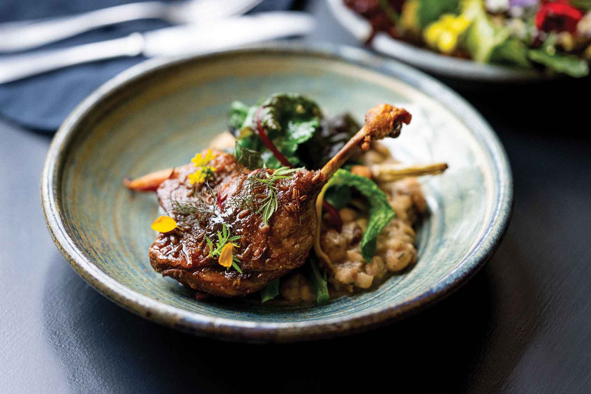 Dish of roasted meat toped with herbs.