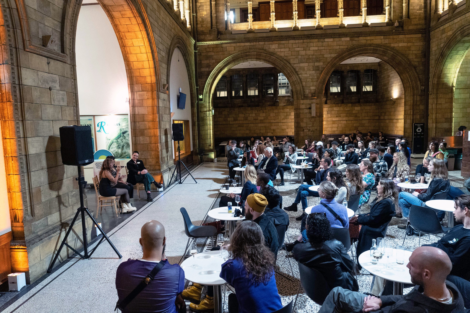 People sat at tables at a talk at the Natural History Museum