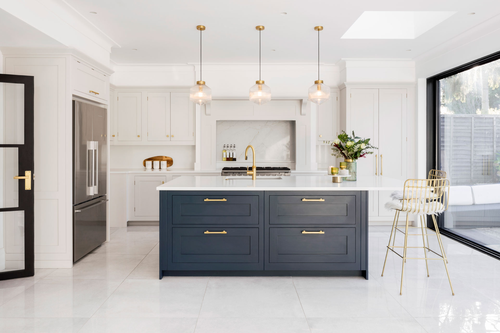 Navy blue kitchen island with white countertops and floors.