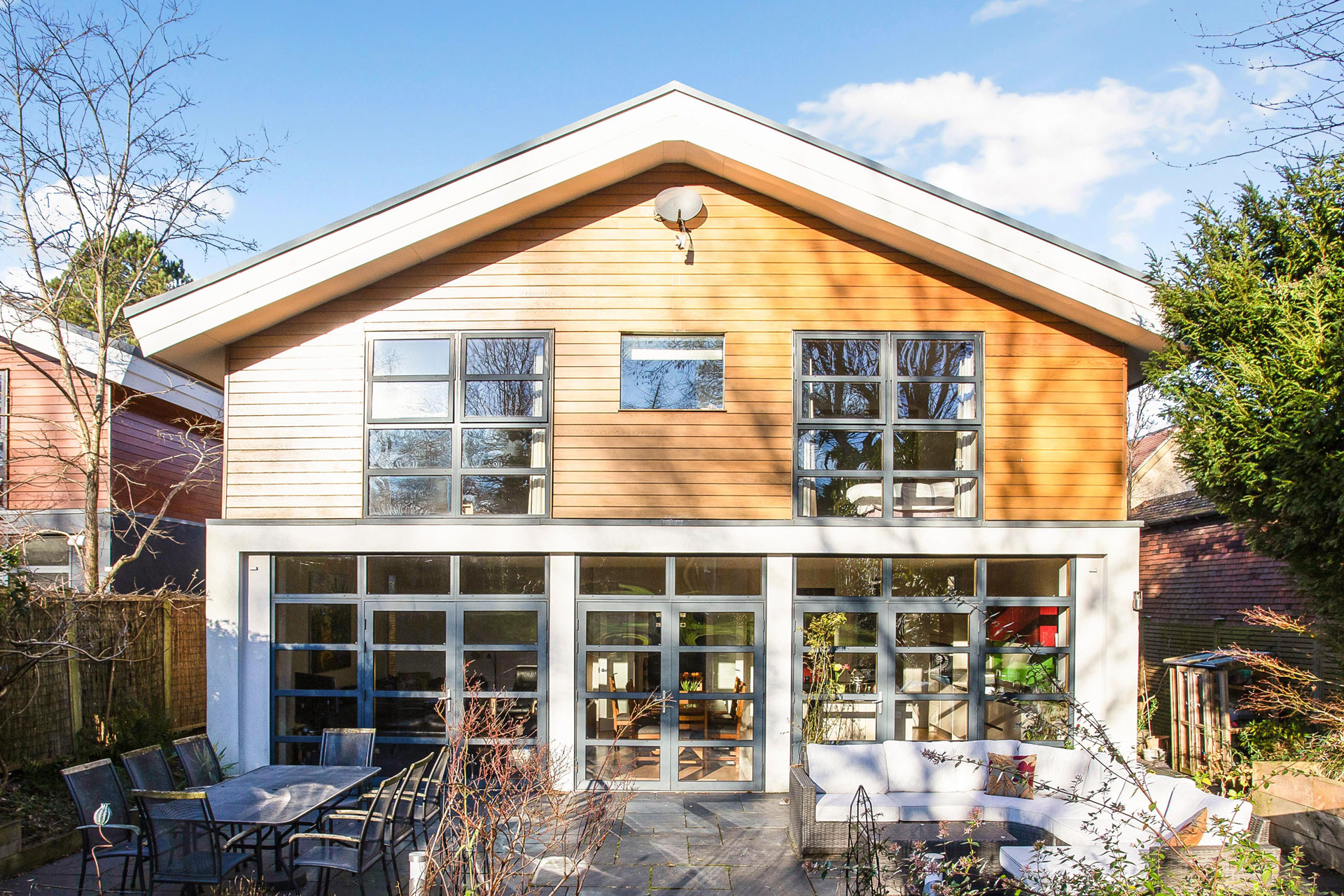 New build home with wooden panelling and a glass extension.