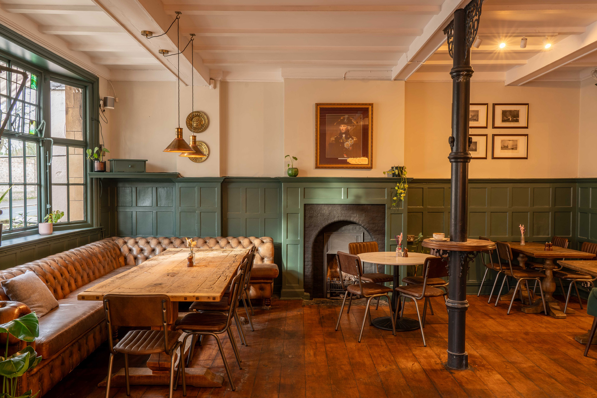 The interior of a pub with tables and a fireplace