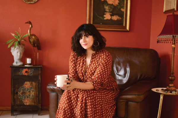 Beauty journalist Jessica DeFino sitting holding a cup