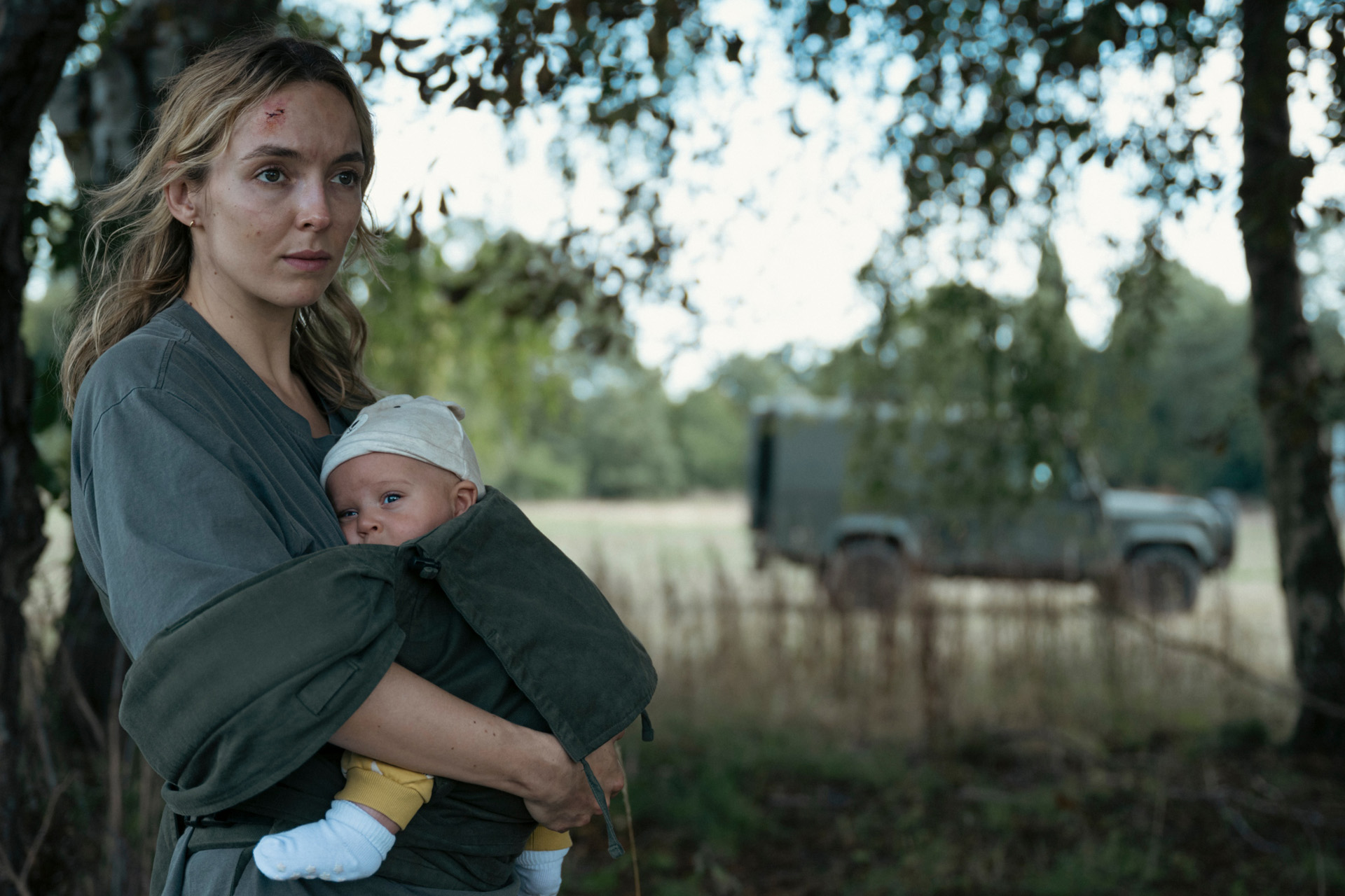 Jodie Comer beside an army vehicle