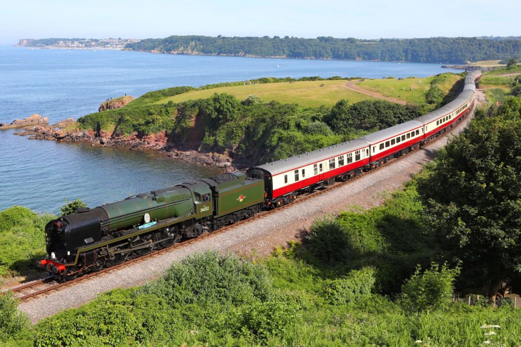 A steam train travelling through the British countryside