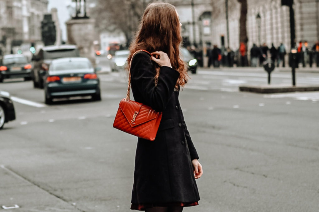 Woman on streets with red bag