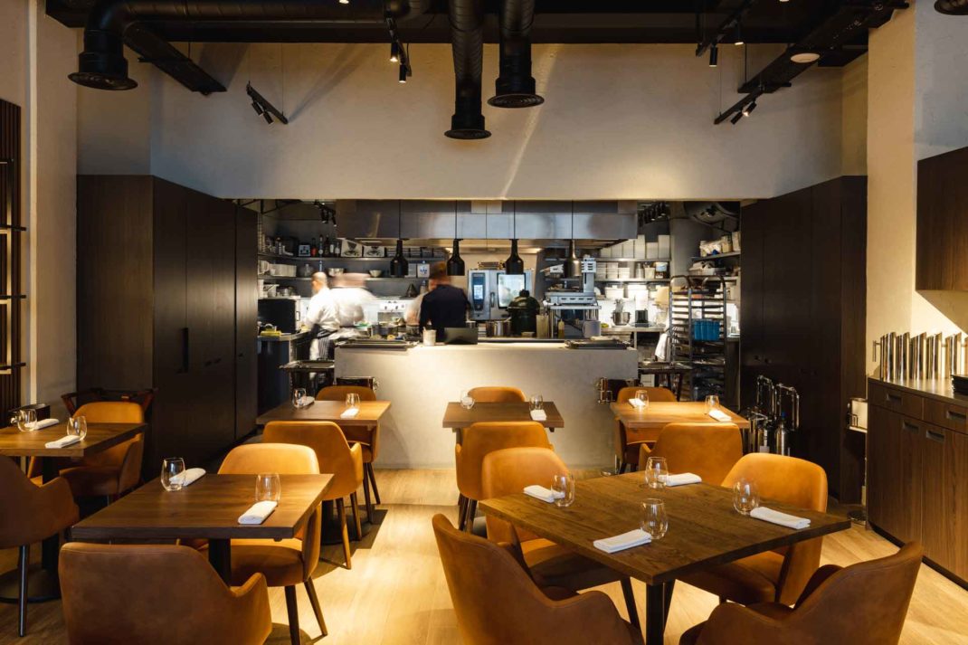 Restaurant with dark wooden tables and ochre yellow chairs