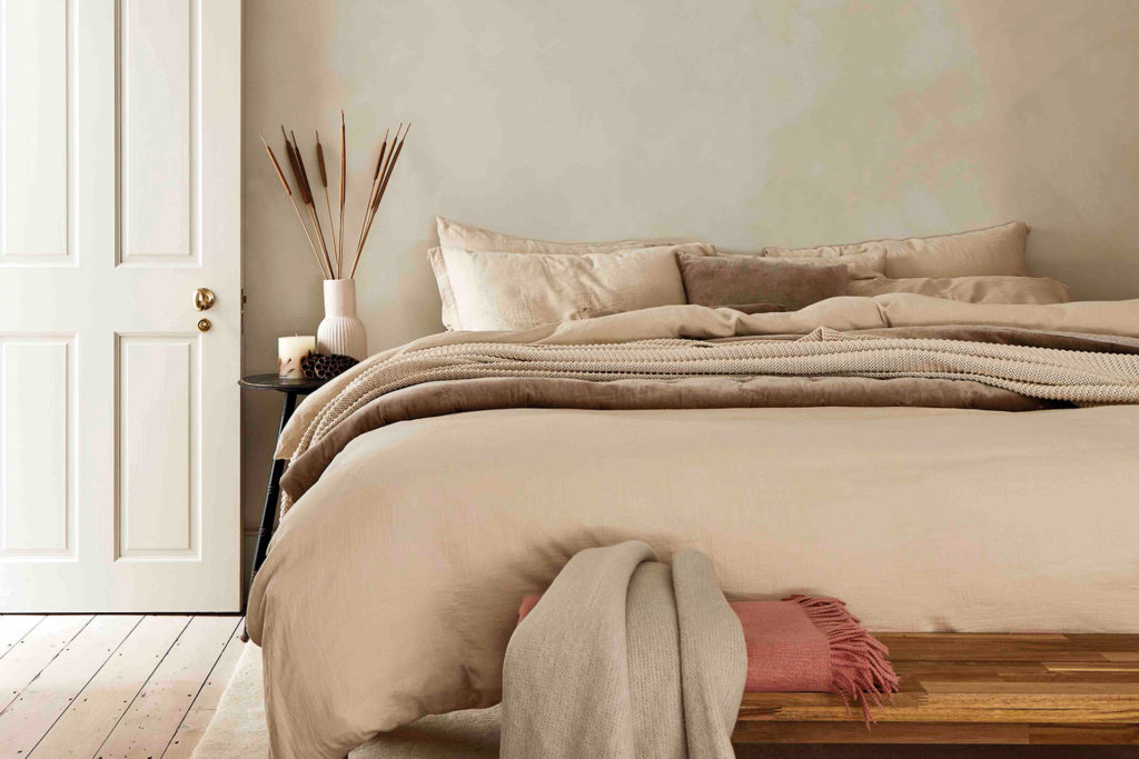 A bed with neutral bedding