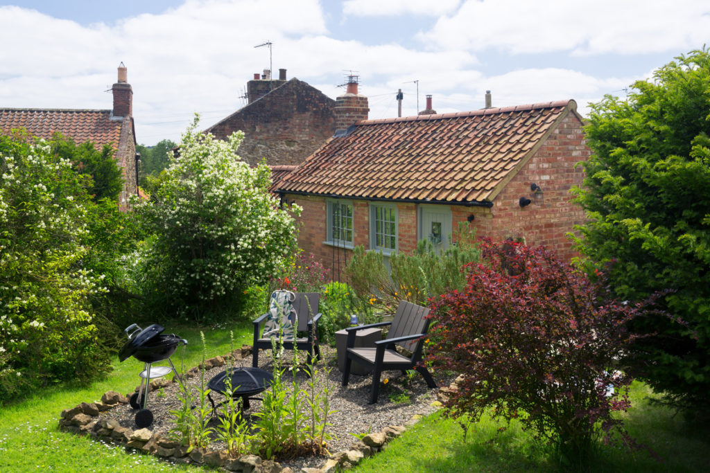 A quaint red brick cottage with a little garden