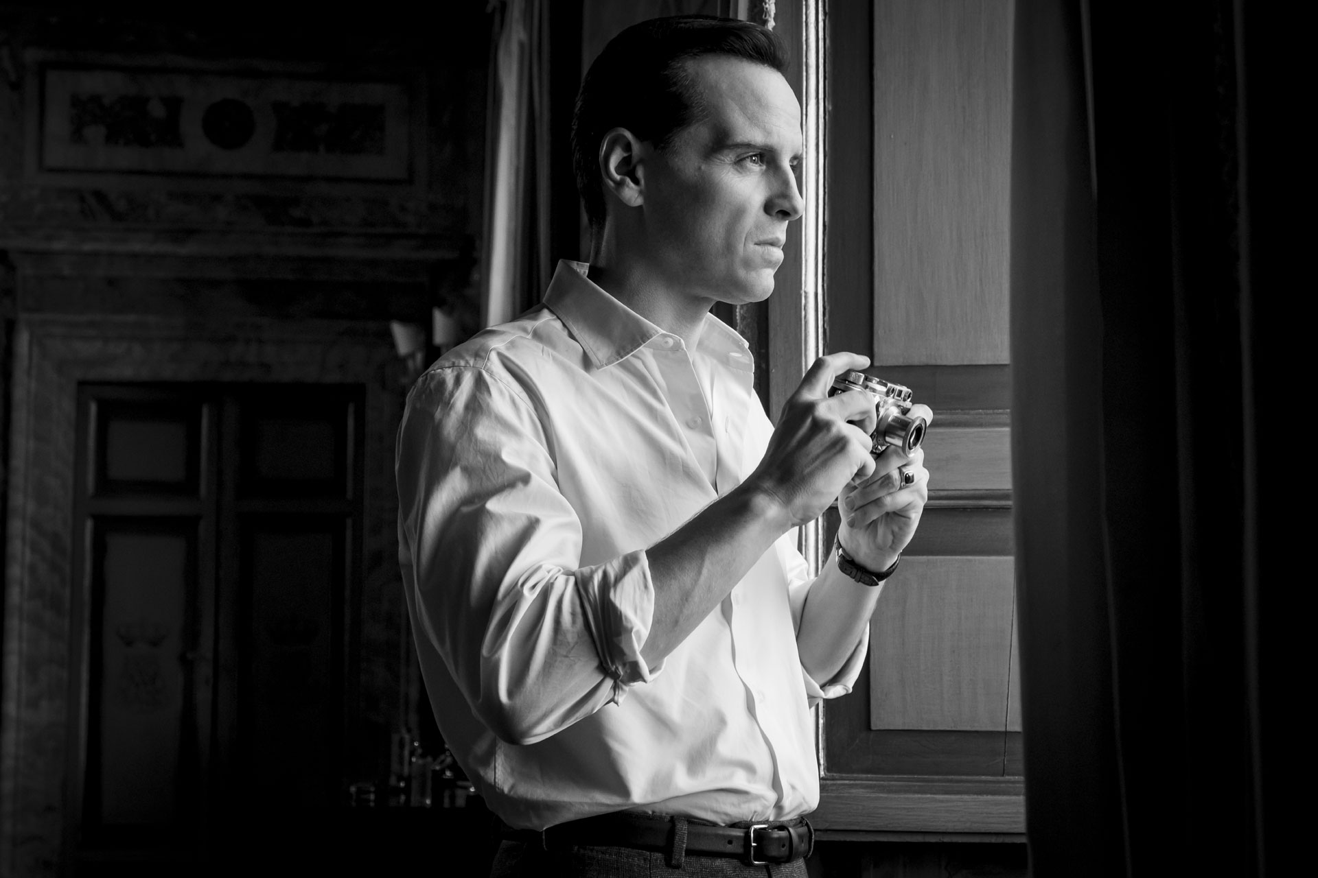 Andrew Scott as Tom Ripley, holding a camera.