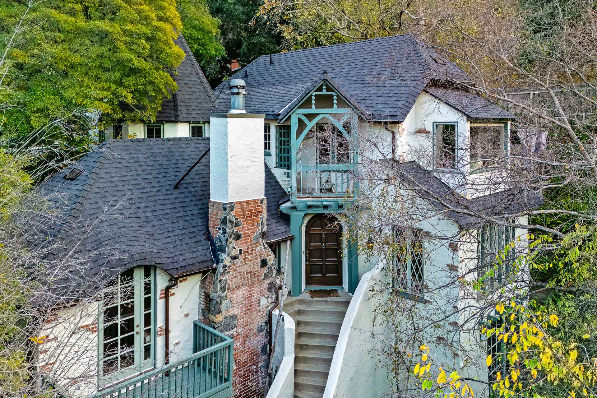 Exterior of Laurel Canyon cottage with slate roof and mint-green terraces.