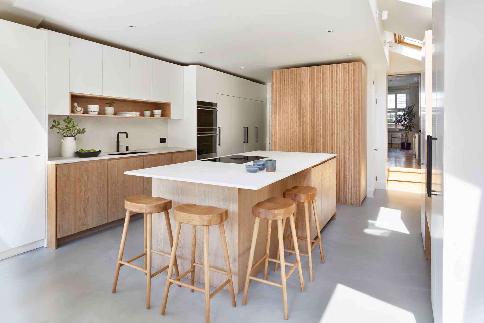 Kitchen with concrete floors, warm wooden cabinets and white countertops