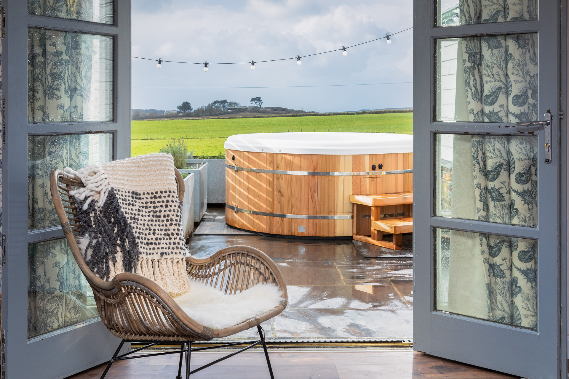 Two doors opening onto a patio with a hot tub