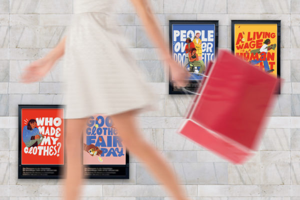 A figure in a dress walking past posters about fairer fashion