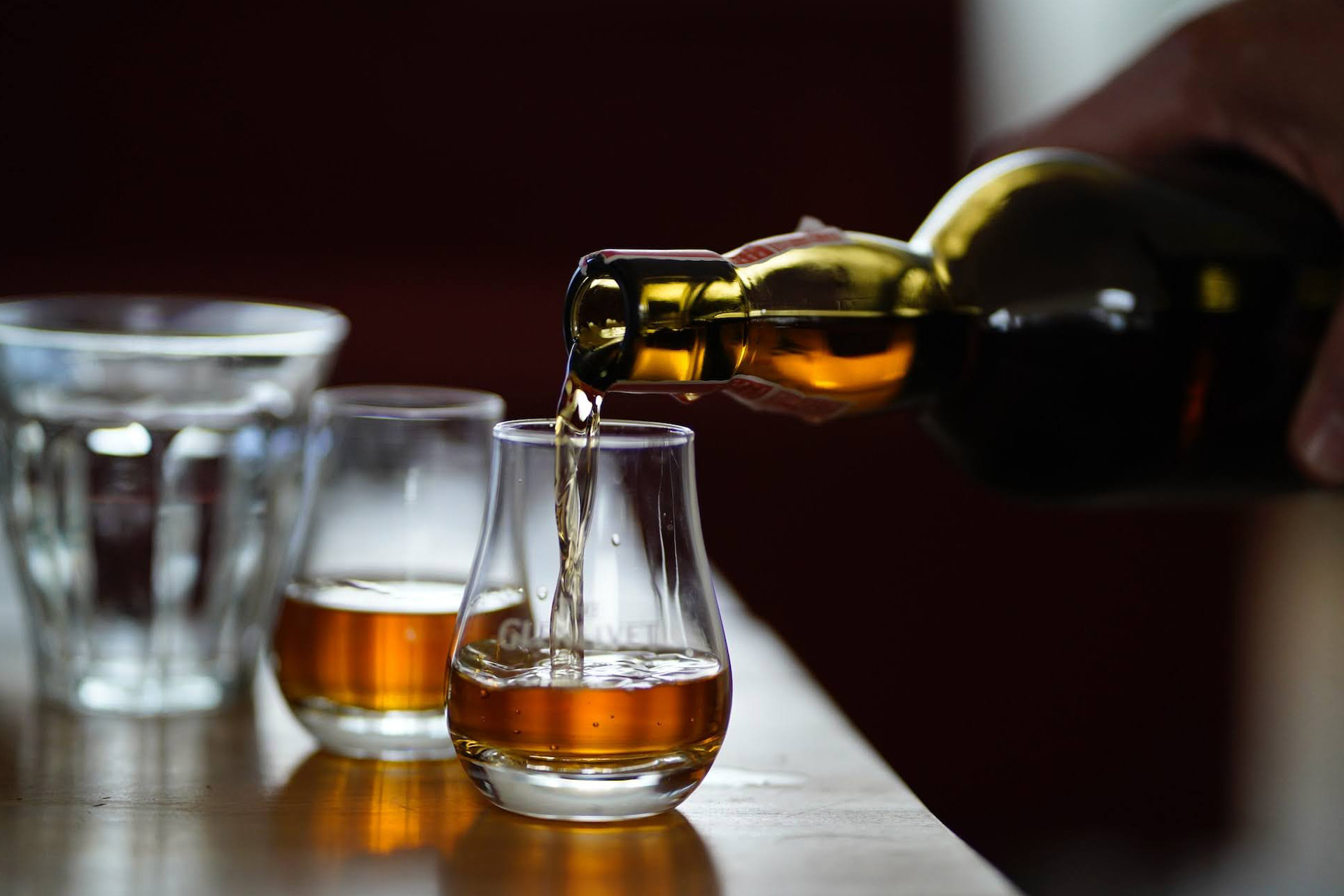 Whisky being poured into a glass from a bottle