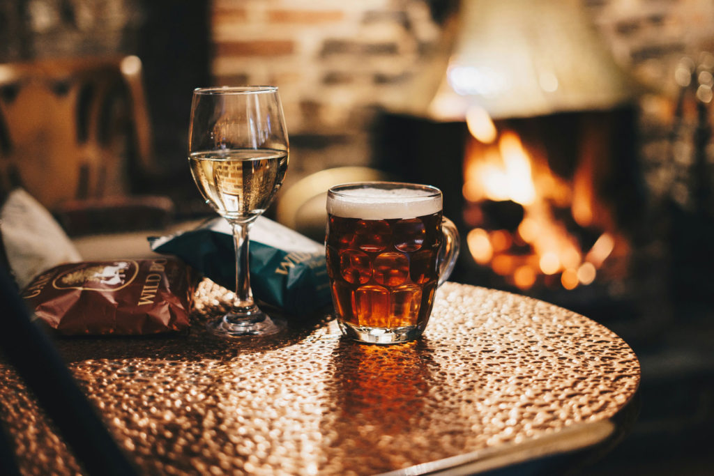 Pint and glass of wine by the fire in a pub