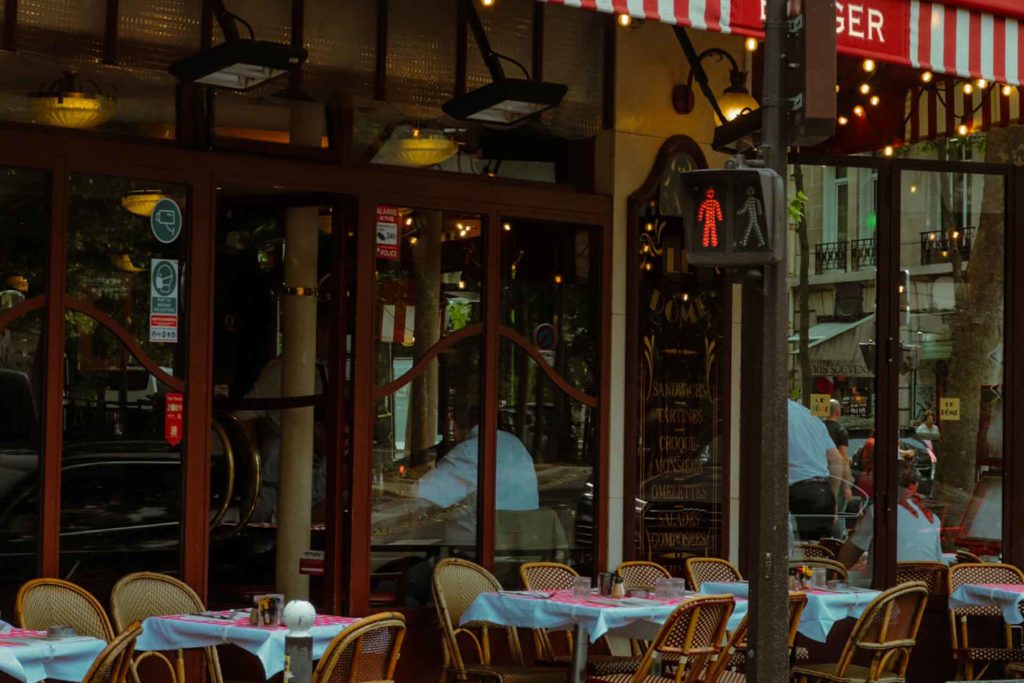 Traditional French bistro with red and white awnings.