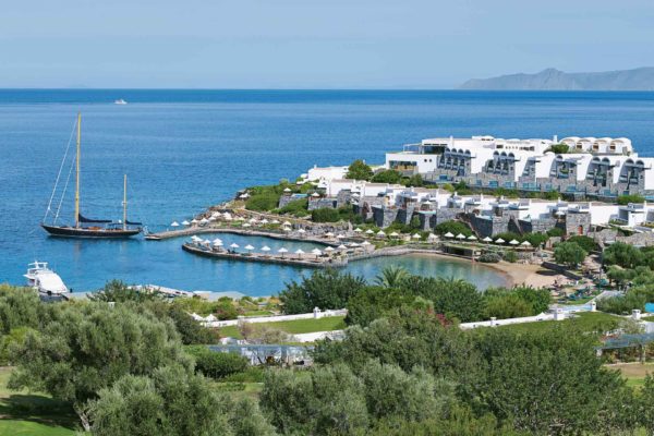 View of waterfront resort, with boats sailing in the bay.