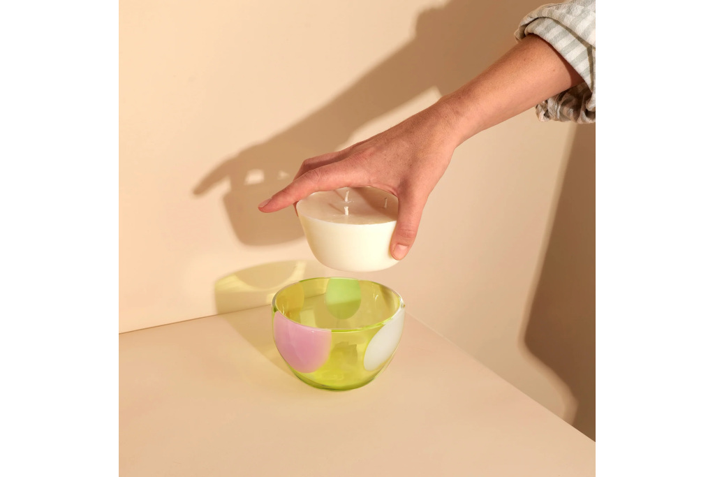 Hand placing refillable candle in dish