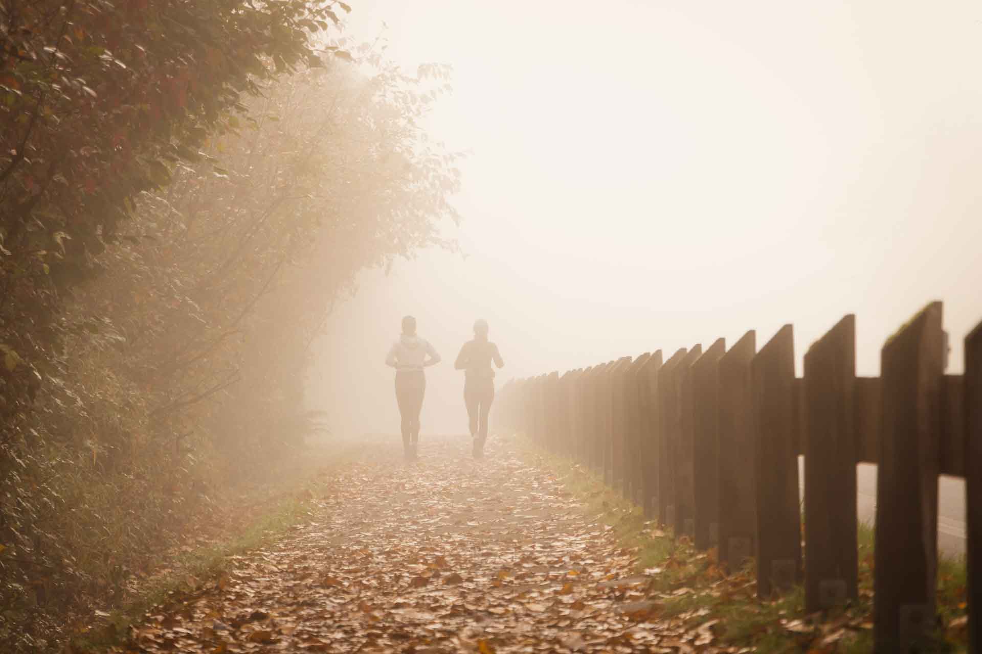 Couple jogging on a misty autumn day