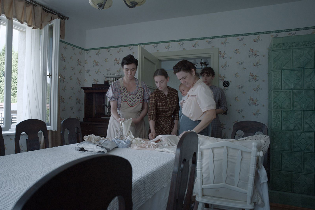 Three women standing beside a dining room table