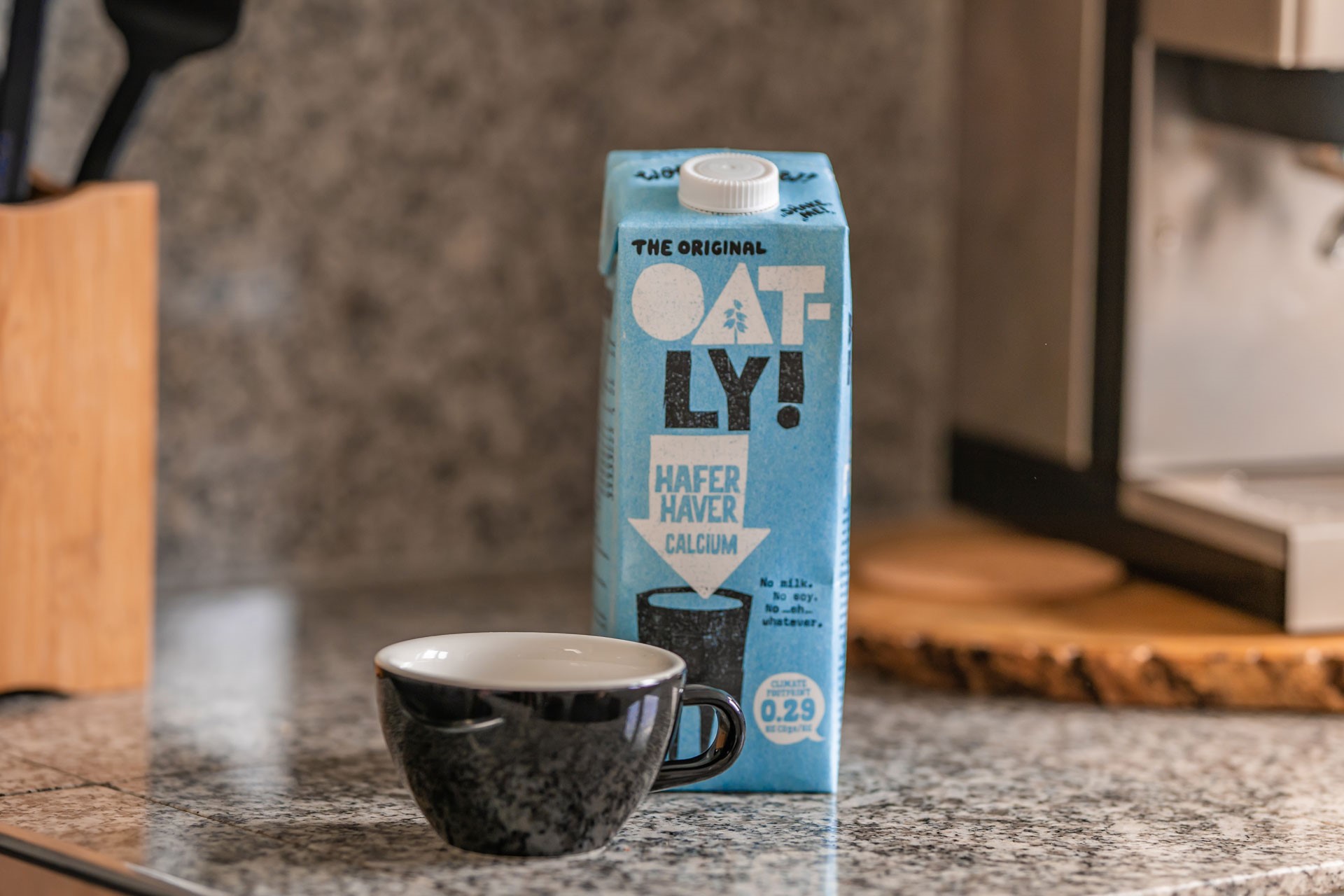 Carton of oat milk with a mug