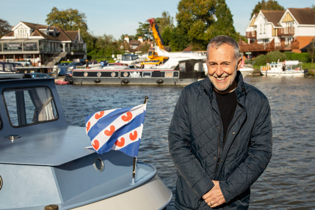 Michel Roux standing by a boat on the river