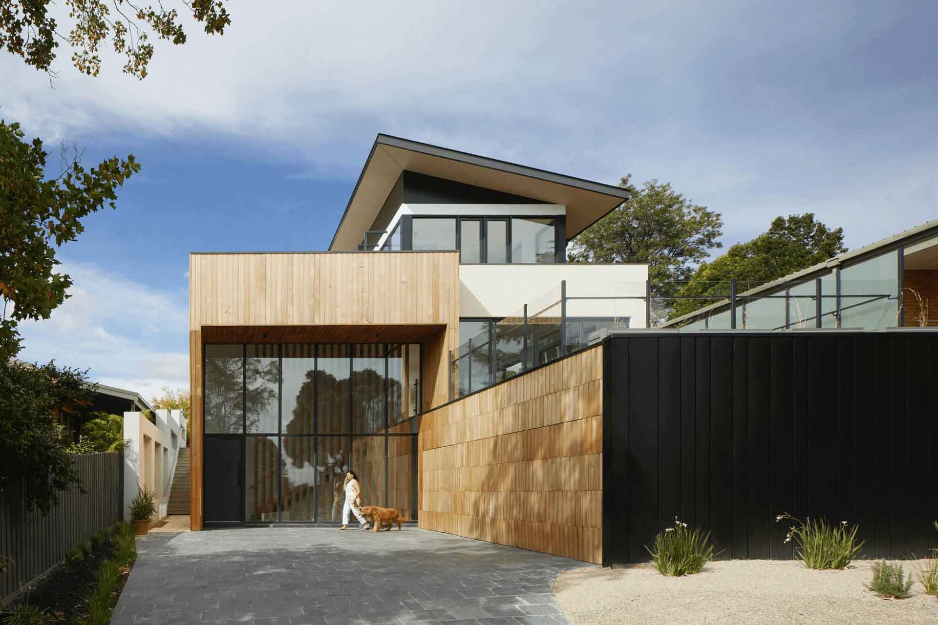 Modern home with wood panelled exterior and floor-to-ceiling windows.