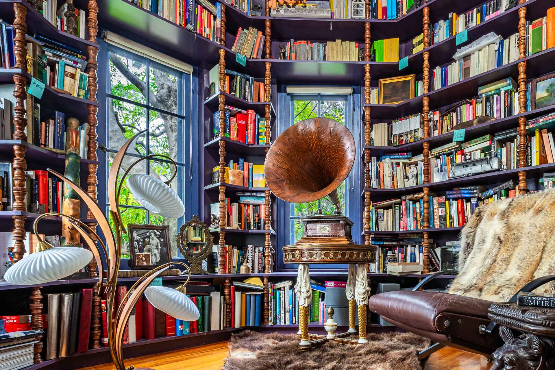 Octagonal library with floor-to-ceiling bookshelves and blue window frames.